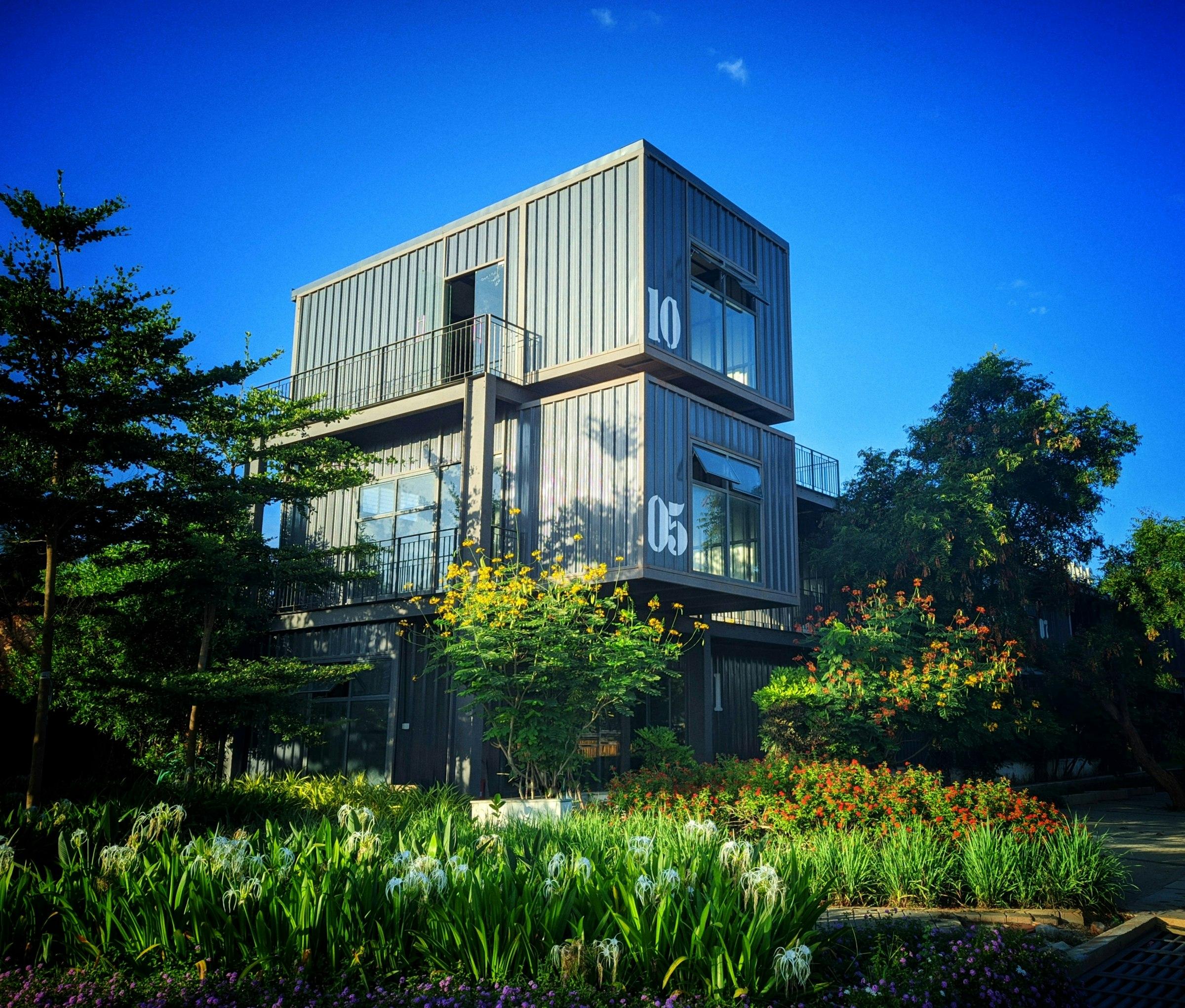 A three-storey stacked container building set in a garden
