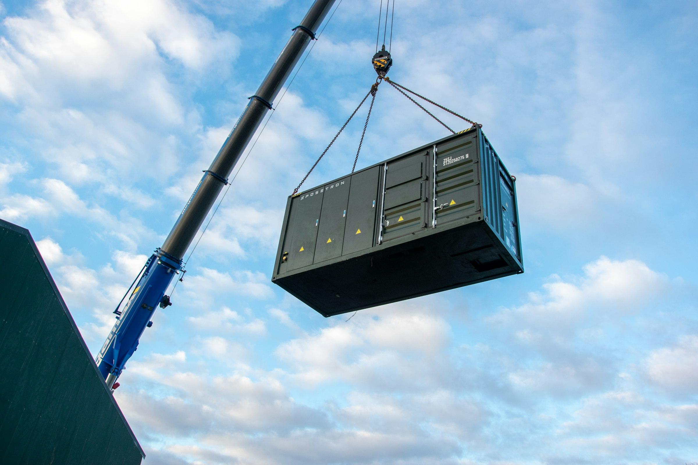 A prefabricated electrical module being lifted into place by crane